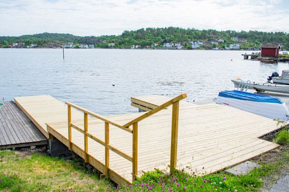 Platting ved sjøen med båter i bakgrunn